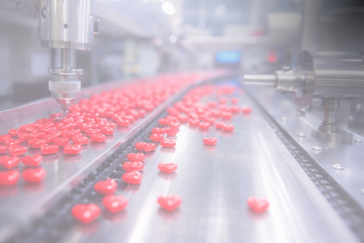 Red tablets moving through a pharmaceutical production line